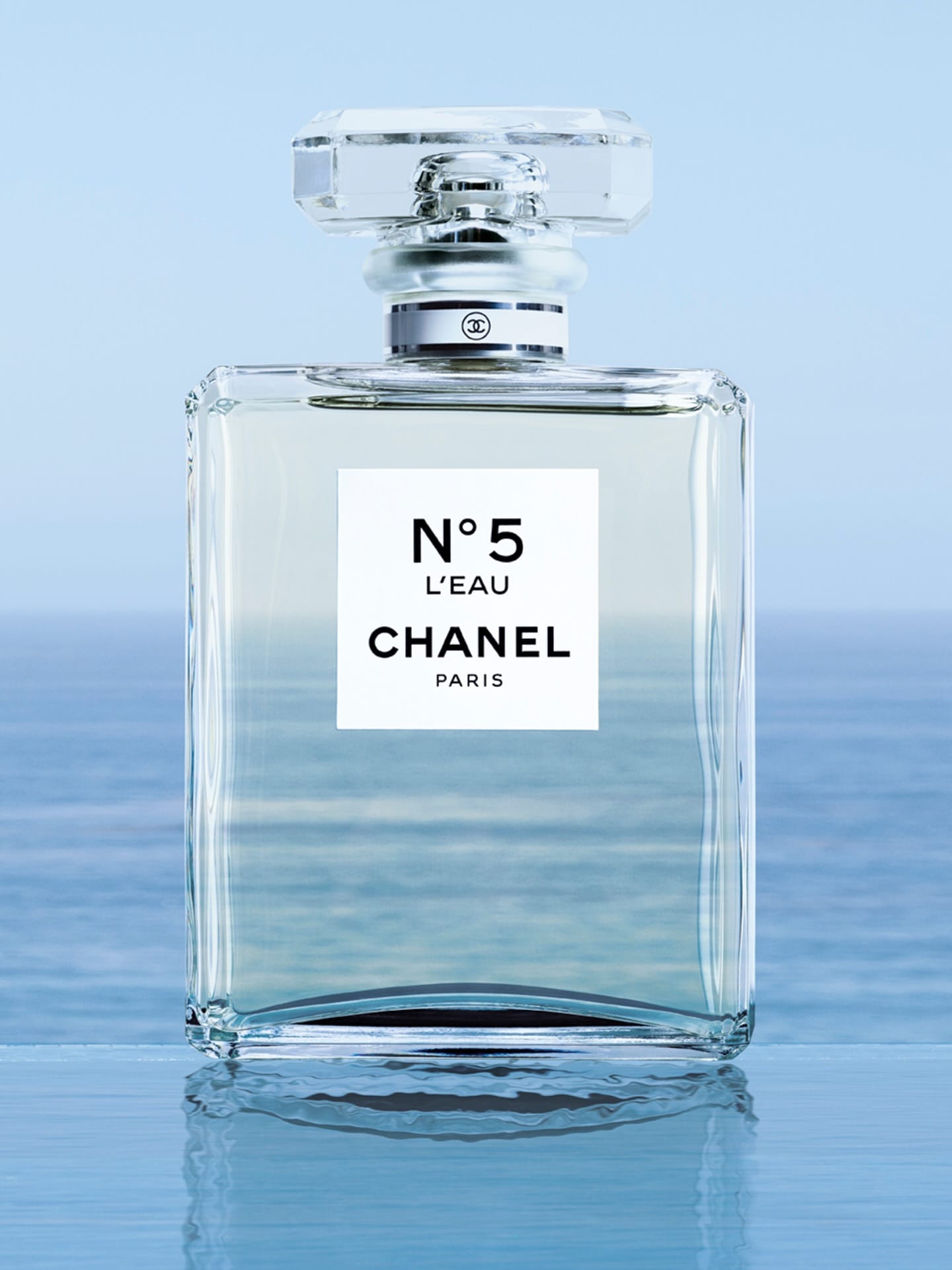 Chanel No. 5 product photo: clear glass, aqua tint, silver cap and white label, glass, natural light
