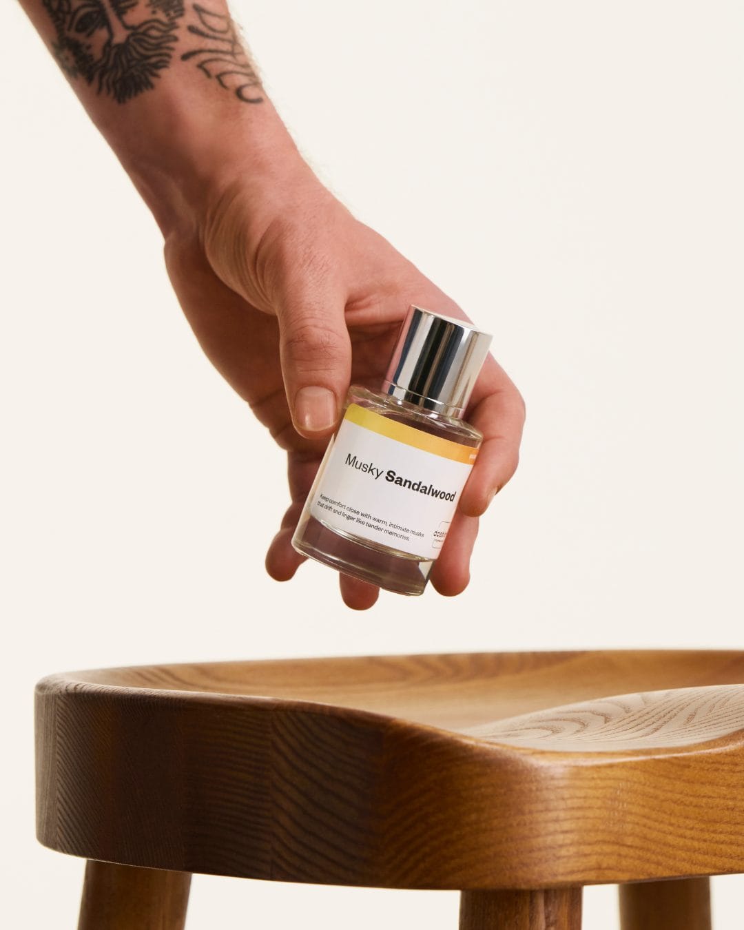 Dossier perfume product photo: clear glass, silver cap and golden amber, glass and wood, studio light, image 3 of 3