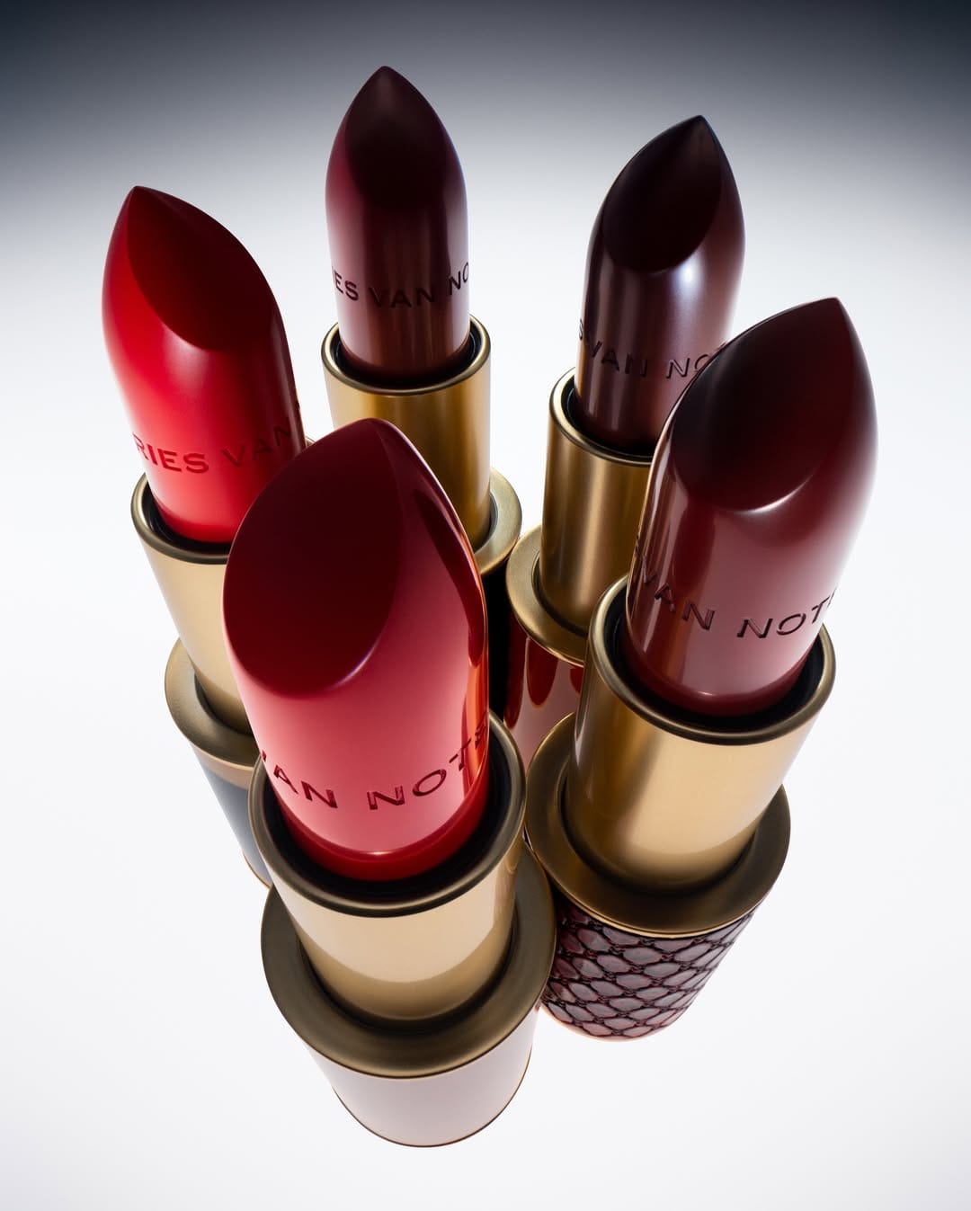Dries Van Noten lipstick product photo: lipstick red, burnished gold and magenta berry, metal, studio light, image 6 of 6