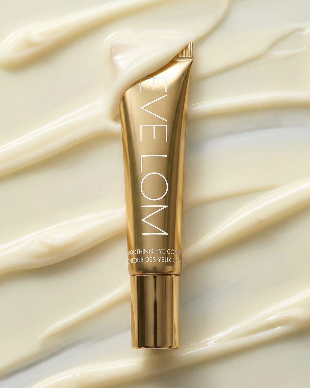 Eve Lom skincare product photo: polished gold, metal, soft light, image 1 of 2