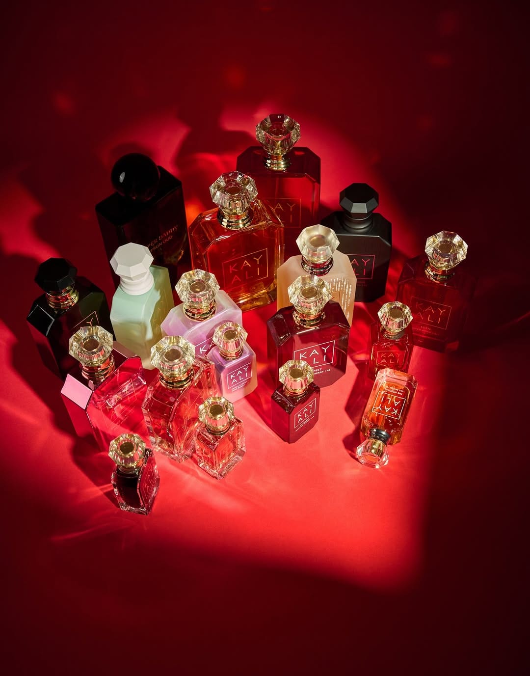 Kayali fragrance product photo: ruby red, peach and rose pink, glass, dramatic light, image 4 of 4