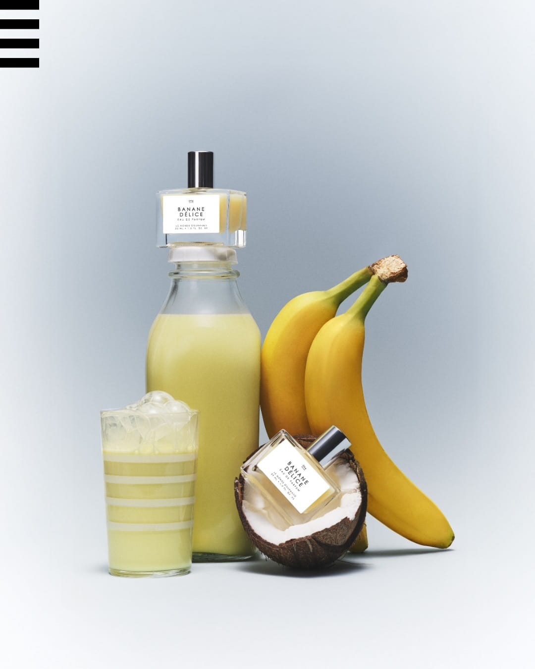 Le Monde Gourmand's Banane Délice product photo: banana yellow, clear glass, silver cap and white label, glass and organic, soft light, image 3 of 3