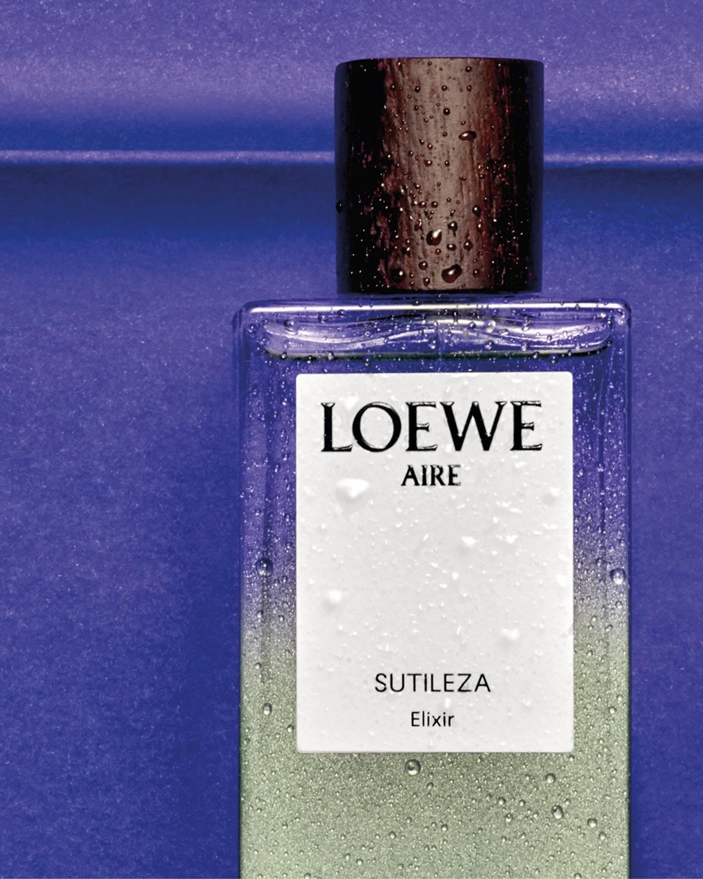 Loewe Aire Sutileza Elixir product photo: clear glass, sage green, white label and black cap, glass, studio light, image 1 of 2