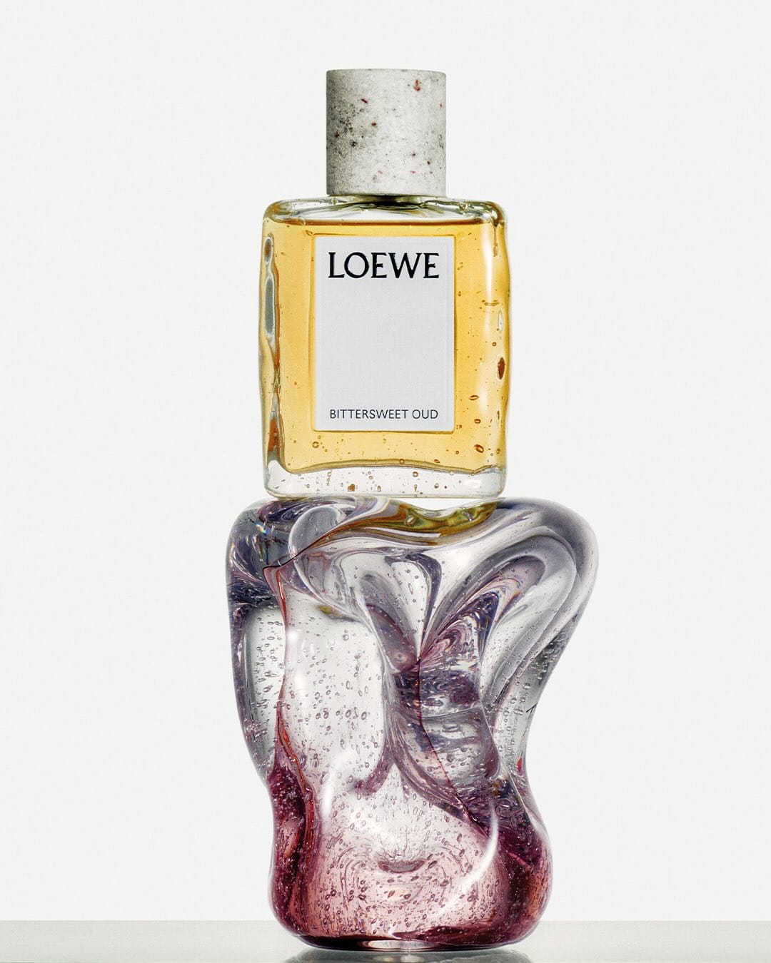 Loewe perfume product photo: clear glass, plum purple, aqua blue and sage green, glass, studio light