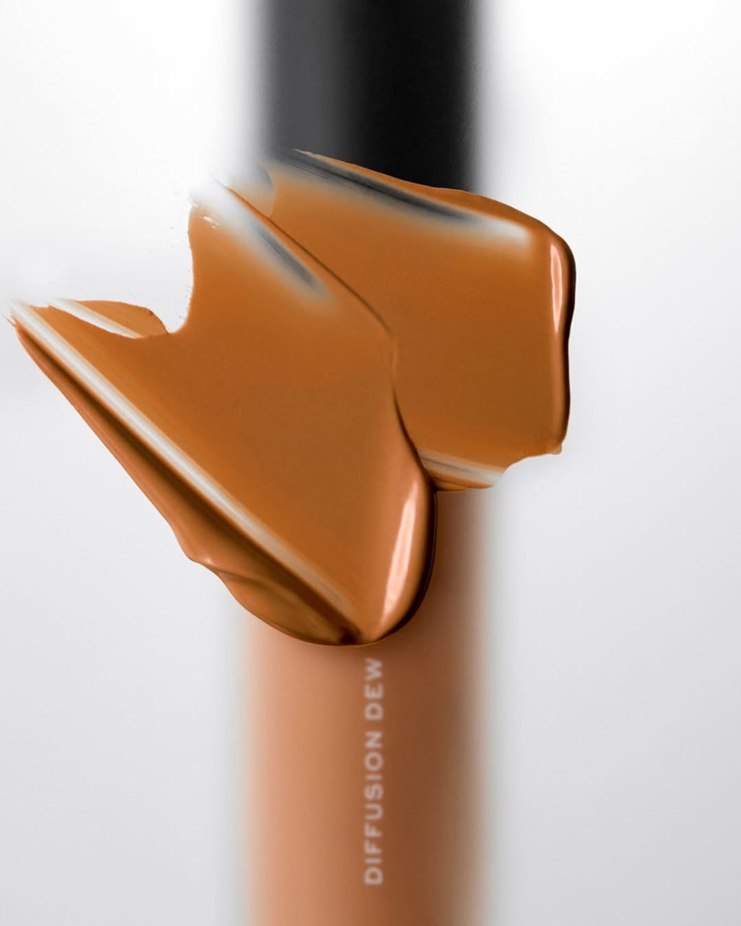 MAKE Beauty Skin Tint product photo: caramel, bronze and peach, plastic, studio light