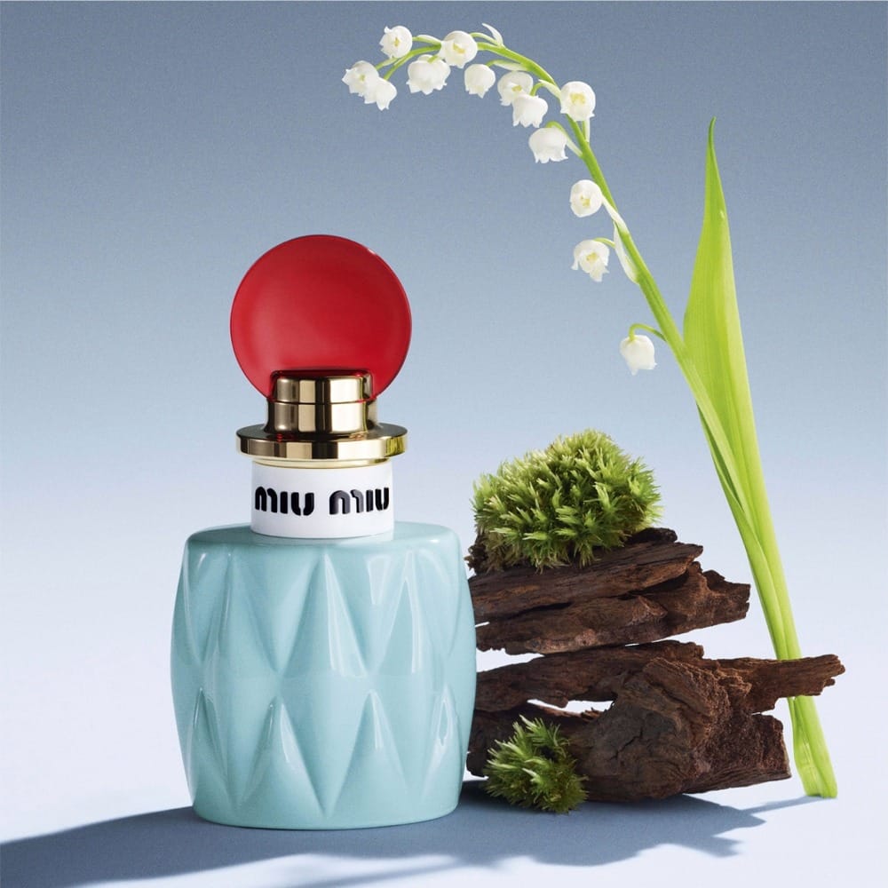 Miu Miu fragrance product photo: powder blue, cherry red, gold collar and white, glass, studio light, image 1 of 3