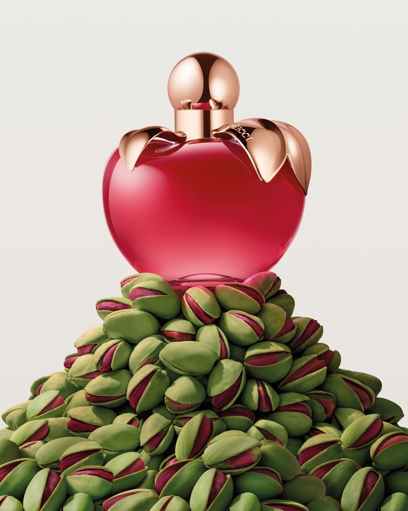 Nina Ricci's anniversary parfum product photo: ruby red, rose gold and blush pink, metal, soft light, image 2 of 5