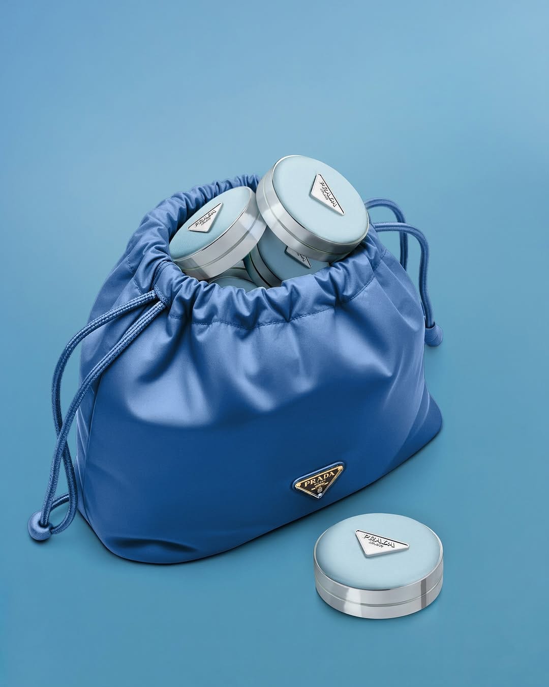 Prada Beauty product photo: periwinkle blue and brushed silver, fabric, soft light