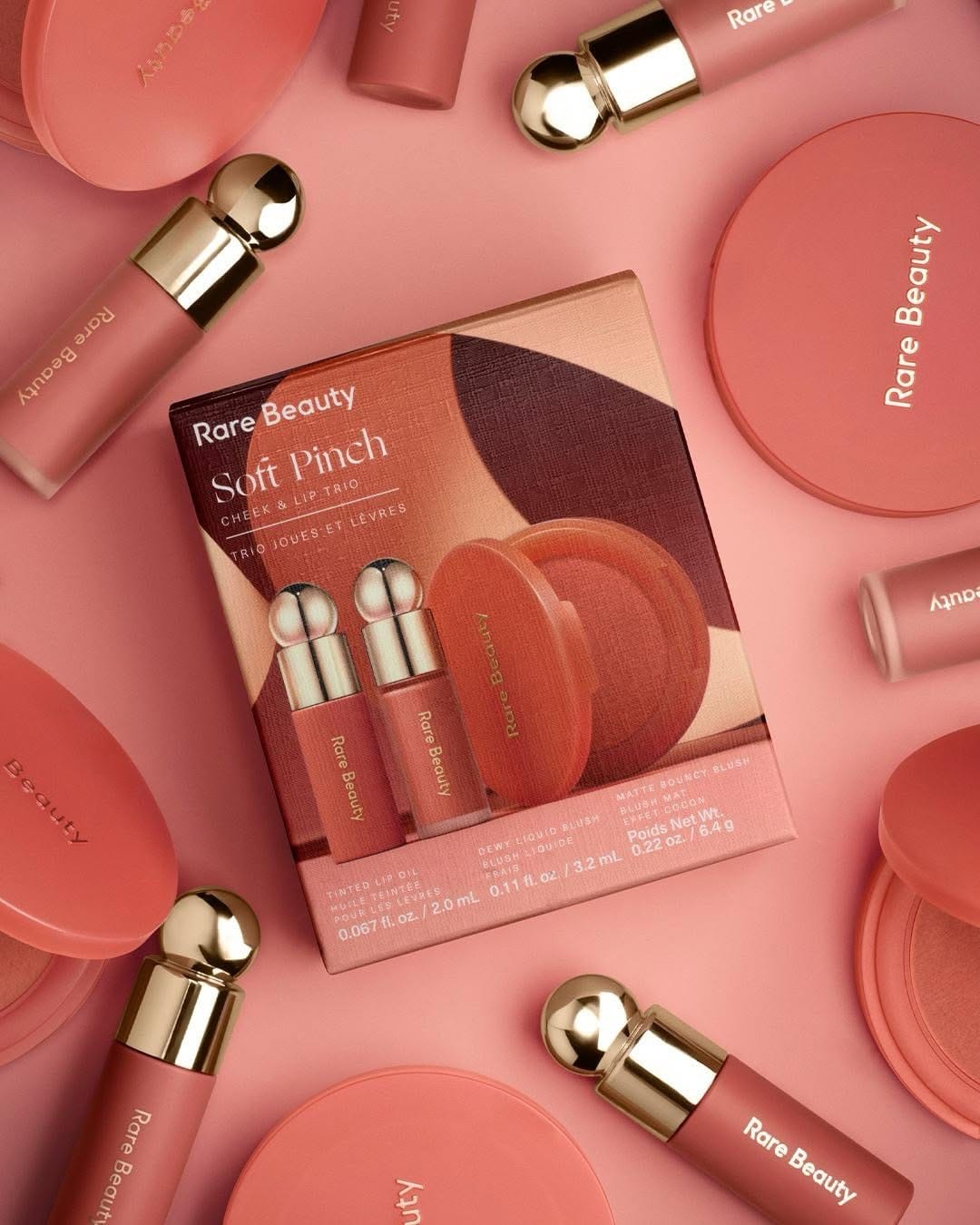 Rare Beauty product photo: coral red, rose pink, cream and gold, paper, soft light, image 2 of 6