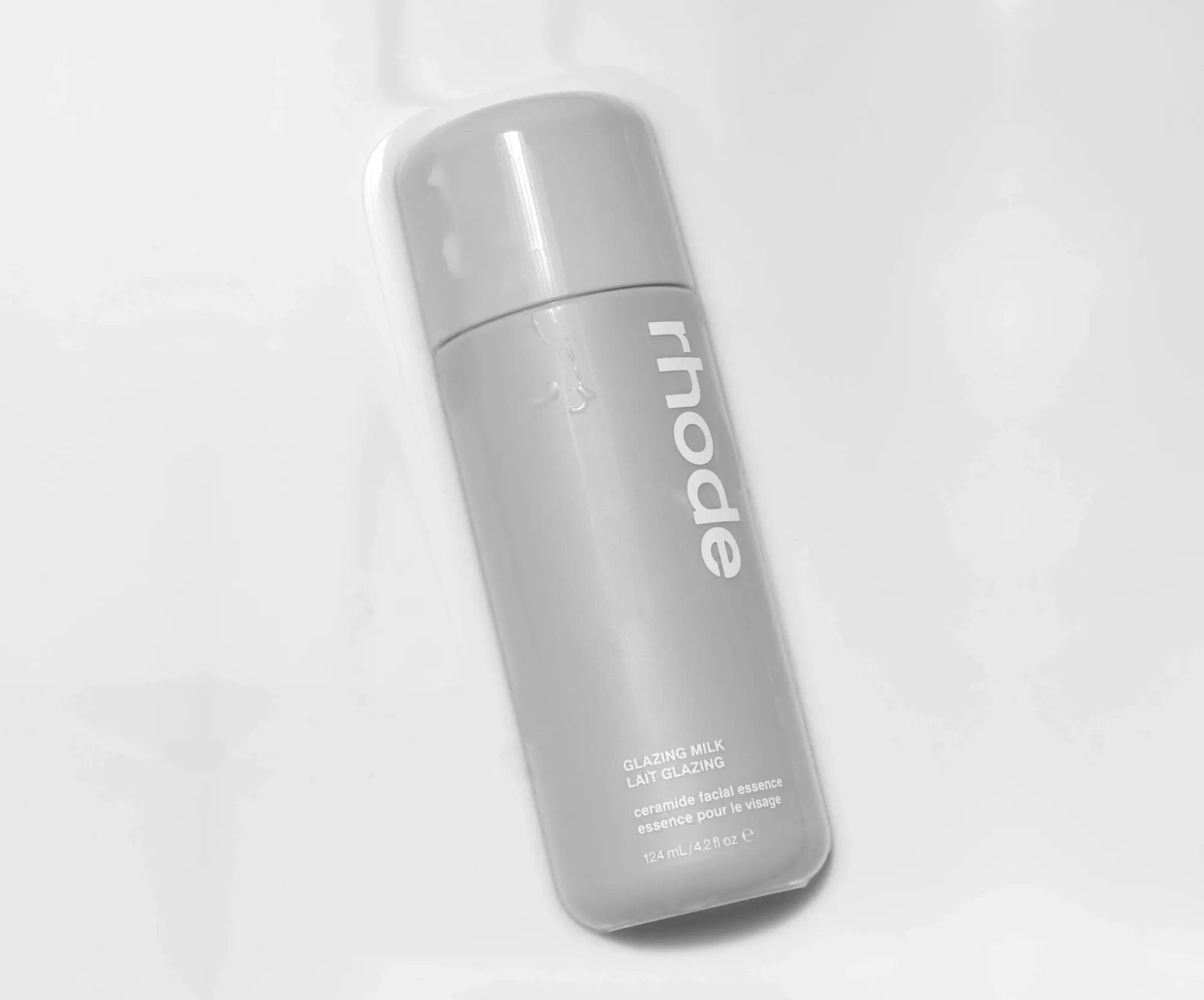 Rhode Skin product photo: soft grey and milk white, plastic and skin, studio light
