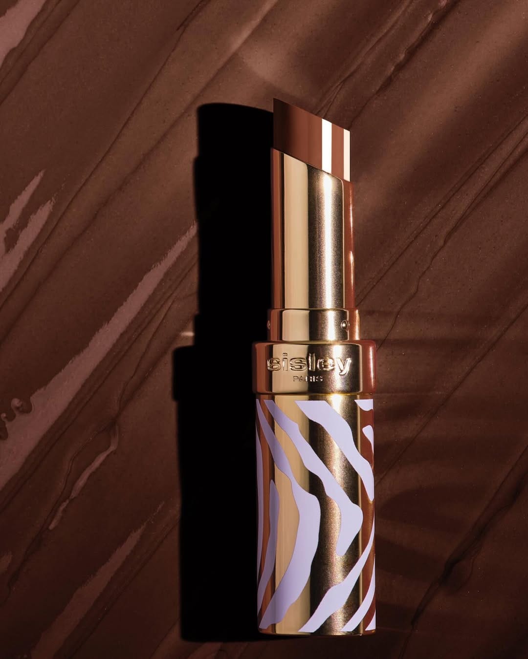 Sisley Paris lipstick product photo: gold, poppy red, chocolate brown and rosewood, metal, soft light, image 2 of 6