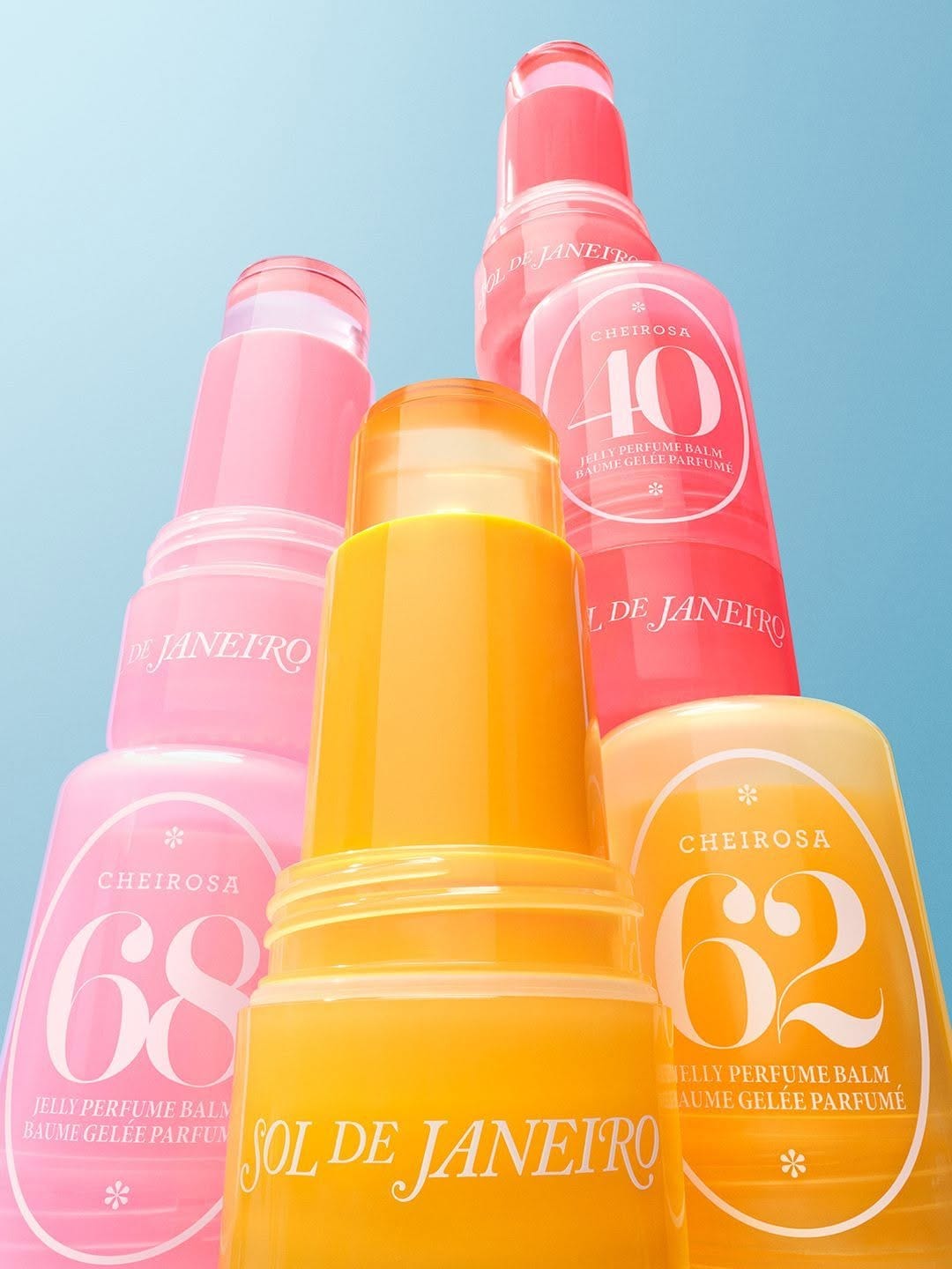 Sol de Janeiro Jelly Perfume Balms product photo: tangerine orange, bubblegum pink, sunny yellow and coral red, skin, natural light, image 1 of 4